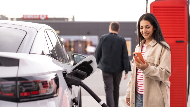 billede af kvinde, der kigger på sin mobil, mens hun starter opladningen