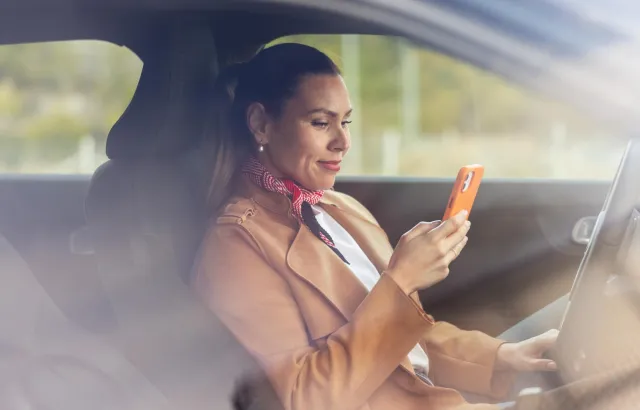 Woman on her phone looking at the Circle K Pro app from her car