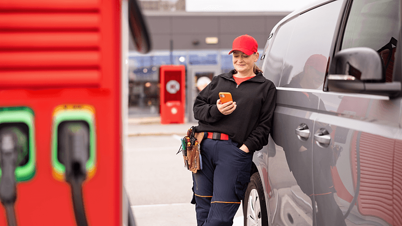 Kvinde med mobil lader firmabil